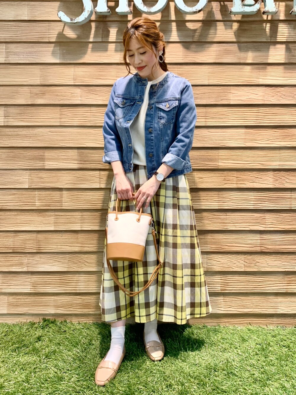 ブルー系のデニムジャケット、ホワイト系のニット/セーター、イエロー系のスカートを着用したレディースの春コーディネートの5枚目の写真