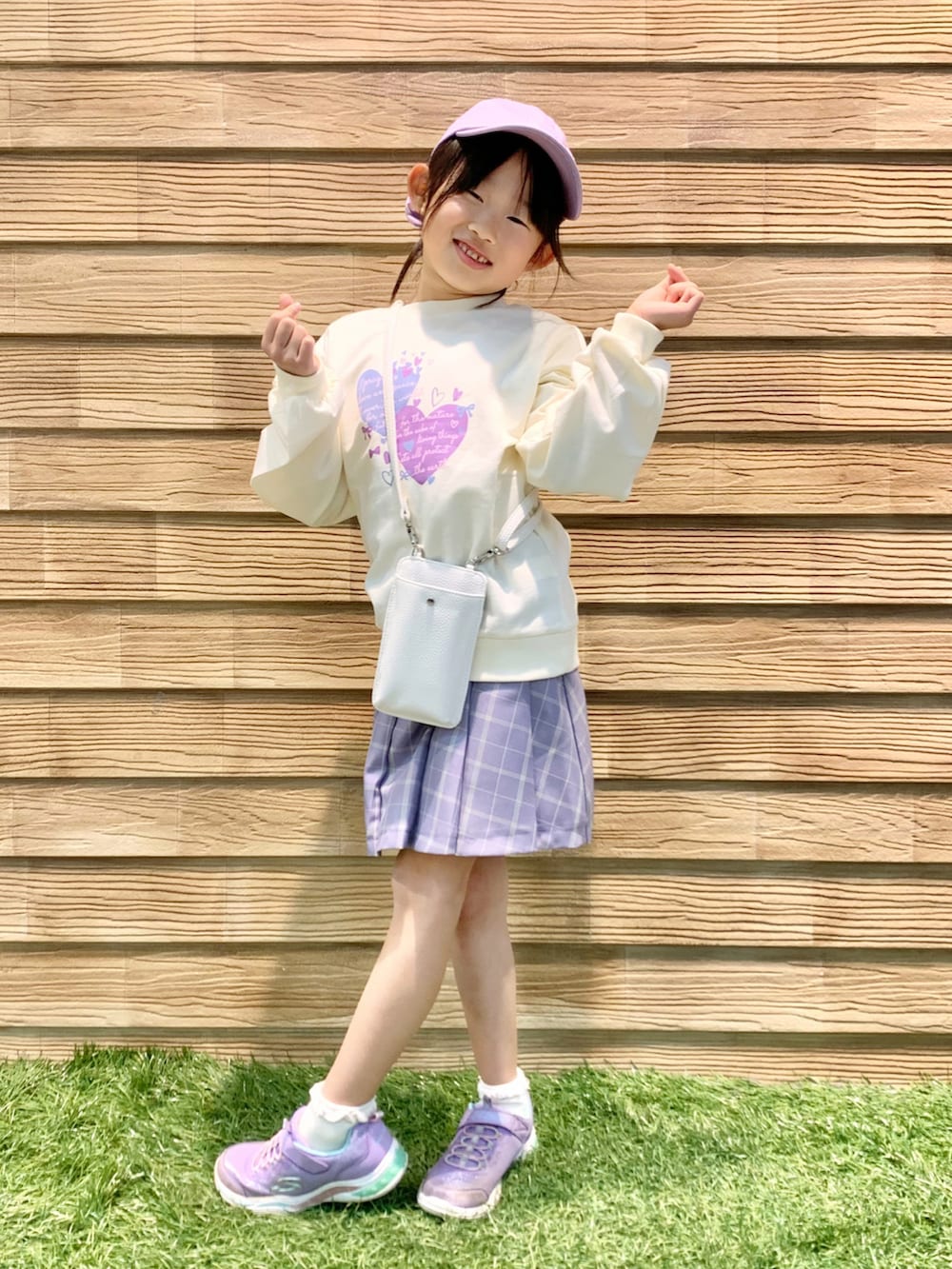 ホワイト系のスウェット、パープル系のスカート、ホワイト系のショルダーバッグを着用したキッズの春コーディネートの2枚目の写真