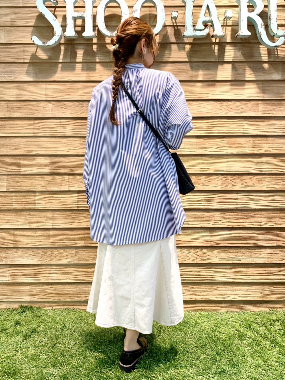 ブルー系のワンピース、ホワイト系のデニムスカート、ブラック系のショルダーバッグを着用したレディースの春コーディネートの5枚目の写真