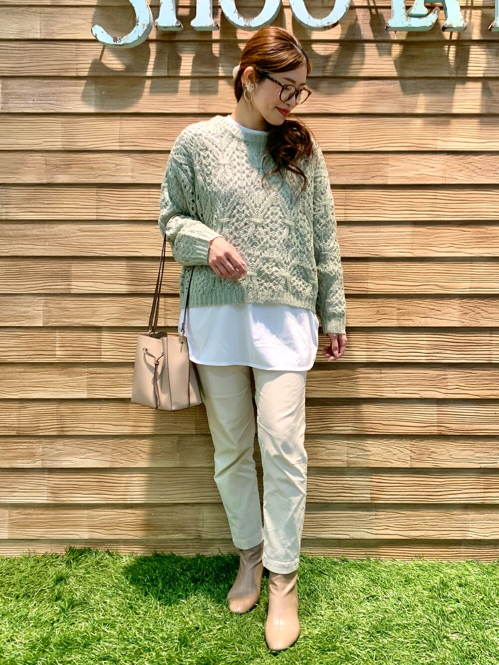 ベージュ系のダウンジャケット/コート、グリーン系のニット/セーター、ホワイト系のその他パンツを着用したレディースの冬コーディネートの4枚目の写真