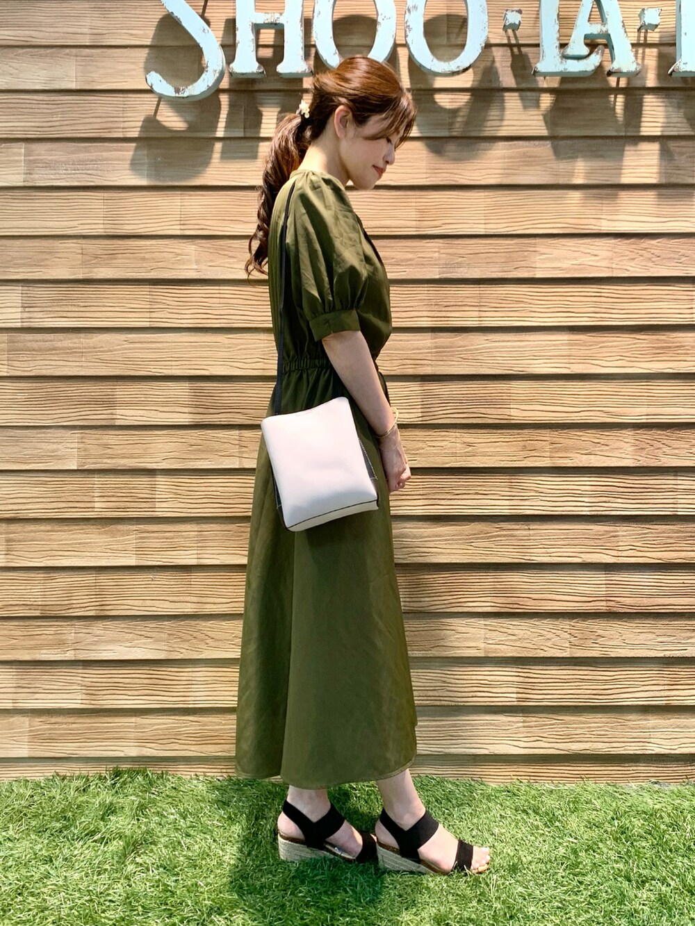 グリーン系のワンピース、グレー系のショルダーバッグ、ブラック系のサンダルを着用したレディースの秋コーディネートの4枚目の写真