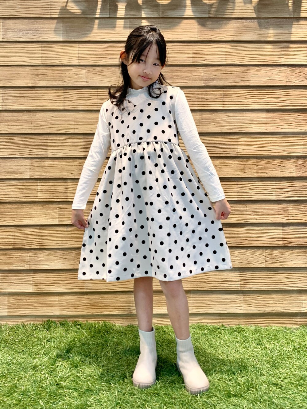 ホワイト系のワンピース、ホワイト系のTシャツ/カットソー、ホワイト系のブーツを着用したキッズの春コーディネートの3枚目の写真