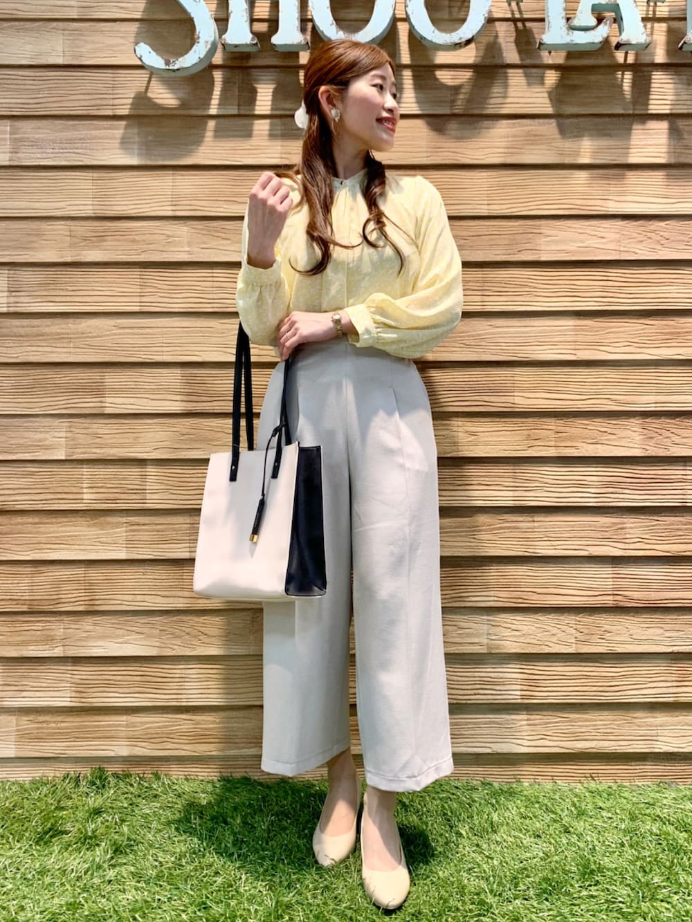 イエロー系のシャツ/ブラウス、ベージュ系のその他パンツ、ベージュ系のトートバッグを着用したレディースの春コーディネートの2枚目の写真