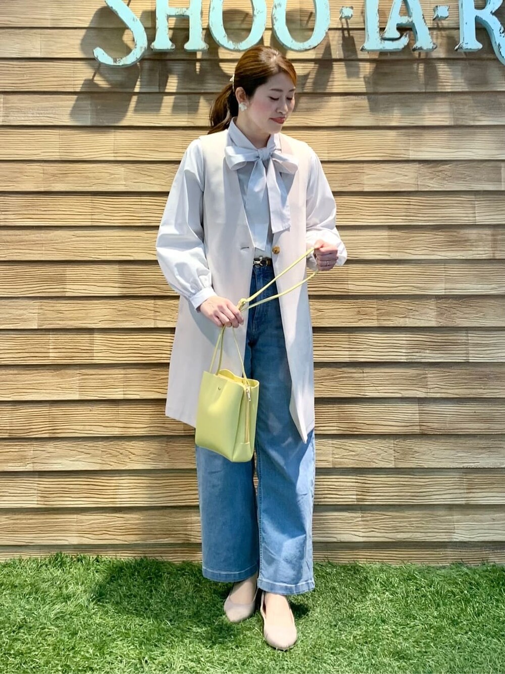 グレー系のシャツ/ブラウス、ベージュ系のベスト、イエロー系のショルダーバッグを着用したレディースの春コーディネートの6枚目の写真