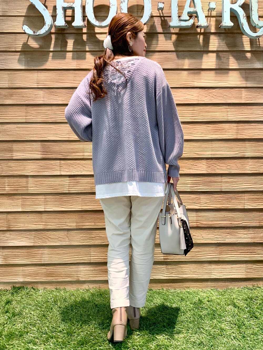 パープル系のニット/セーター、ホワイト系のその他パンツ、グレー系のトートバッグを着用したレディースの冬コーディネートの5枚目の写真