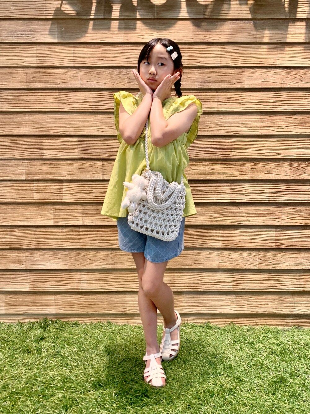 イエロー系のシャツ/ブラウス、ホワイト系のショルダーバッグ、ブルー系のデニムパンツを着用したキッズの夏コーディネートの3枚目の写真
