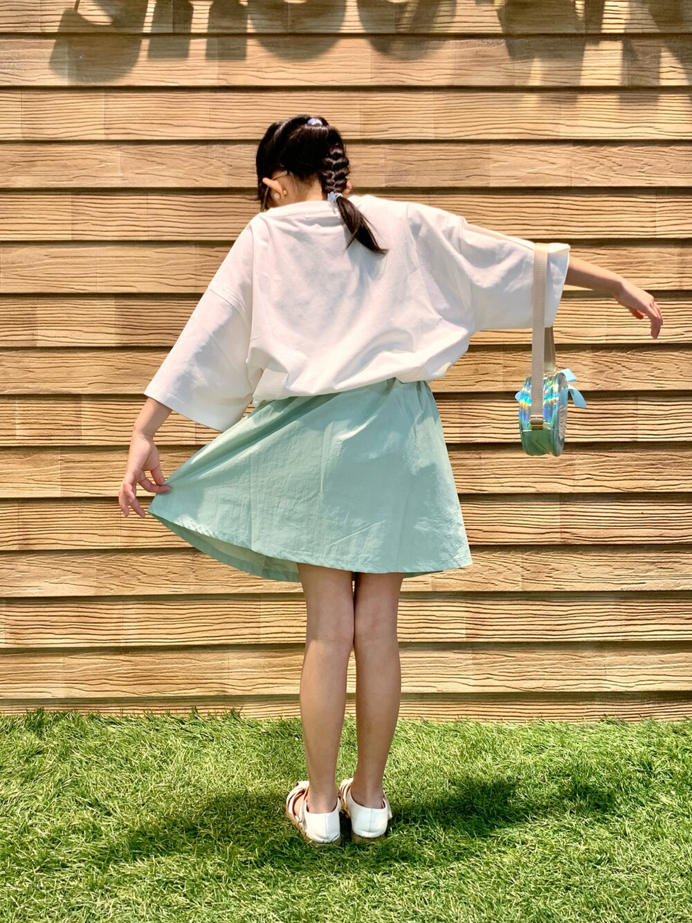 ホワイト系のTシャツ/カットソー、グリーン系のスカート、ブルー系のショルダーバッグを着用したキッズの秋コーディネートの5枚目の写真