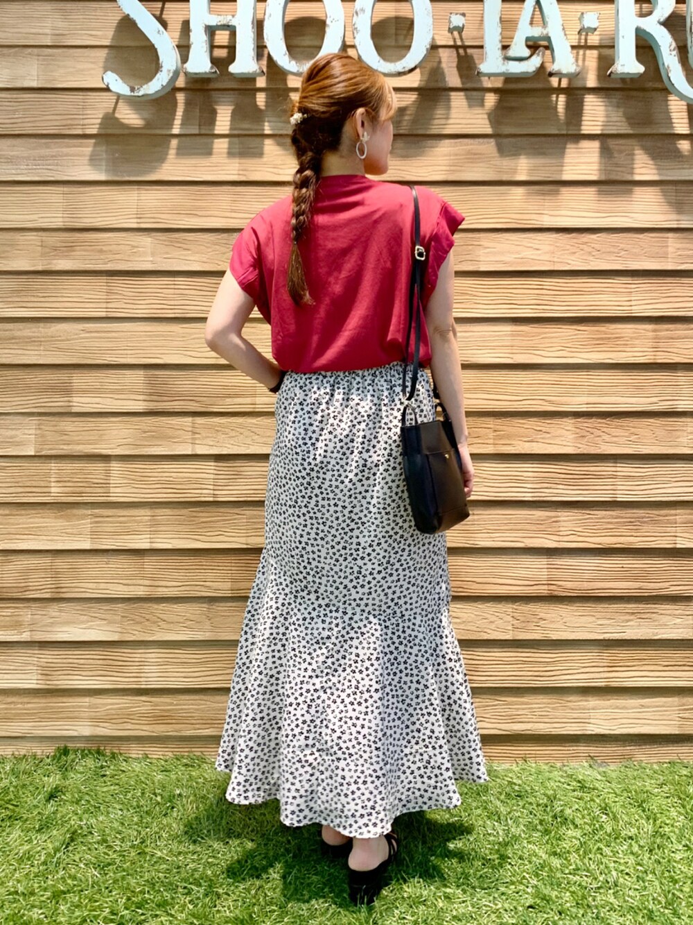 ピンク系のTシャツ/カットソー、ホワイト系のスカート、ブラック系のショルダーバッグを着用したレディースの秋コーディネートの5枚目の写真