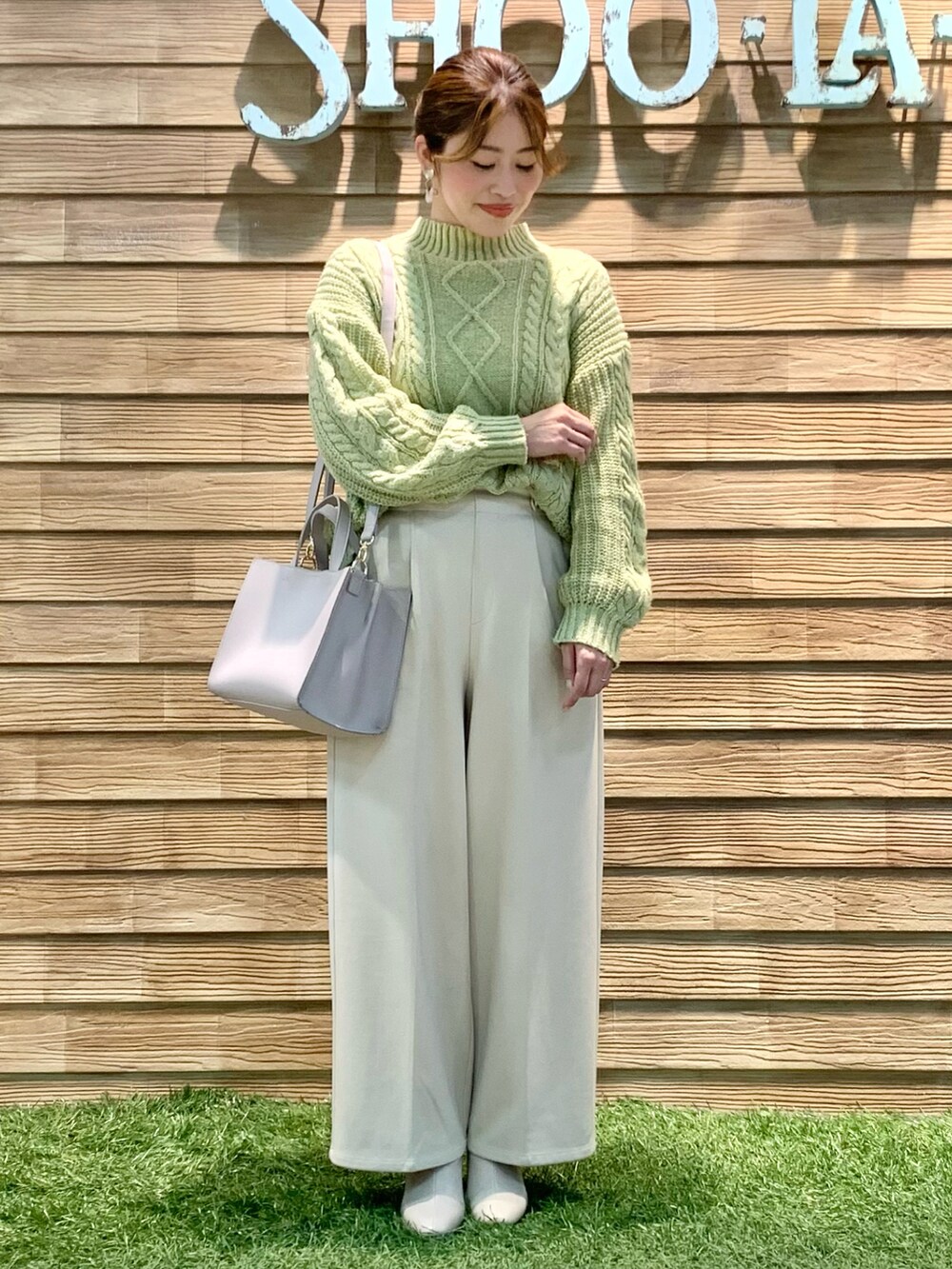 ホワイト系のダウンジャケット/コート、イエロー系のニット/セーター、ベージュ系のその他パンツを着用したレディースの冬コーディネートの2枚目の写真