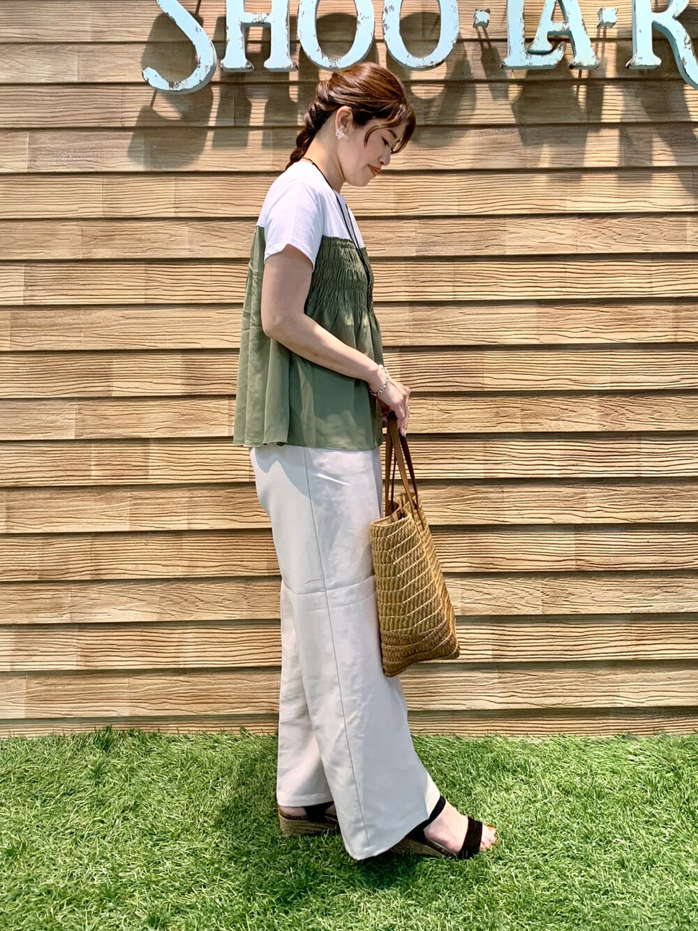 グリーン系のTシャツ/カットソー、ベージュ系のその他パンツ、ブラウン系のトートバッグを着用したレディースの秋コーディネートの4枚目の写真