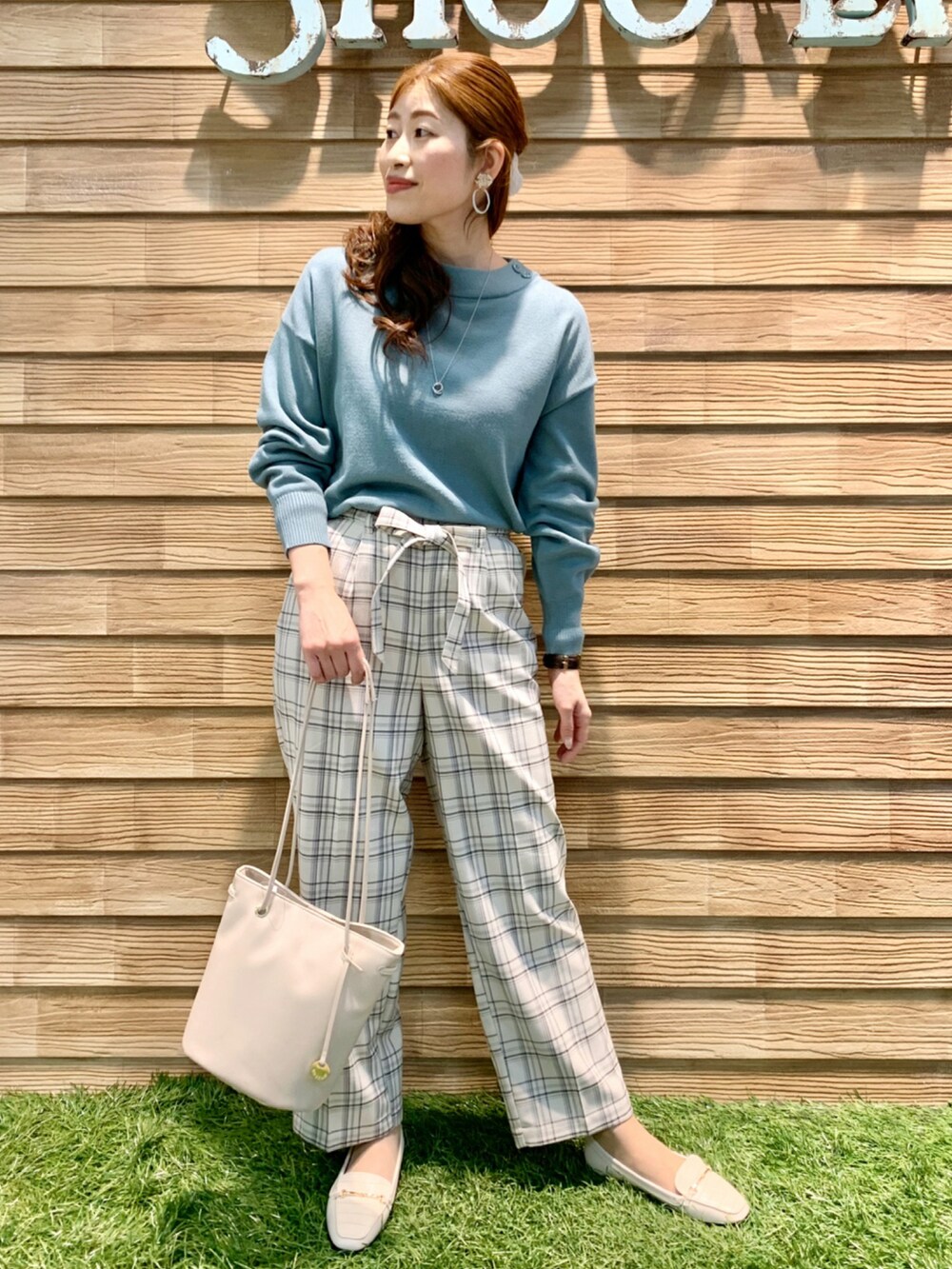 グリーン系のニット/セーター、グレー系のその他パンツ、ホワイト系のトートバッグを着用したレディースの冬コーディネートの2枚目の写真