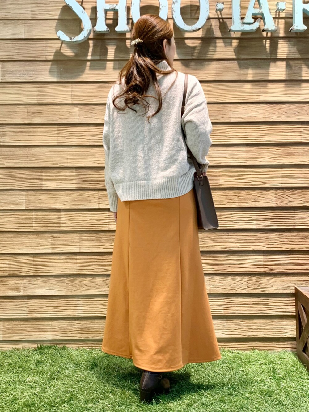 ホワイト系のニット/セーター、オレンジ系のスカート、ブラウン系のショルダーバッグを着用したレディースの冬コーディネートの5枚目の写真