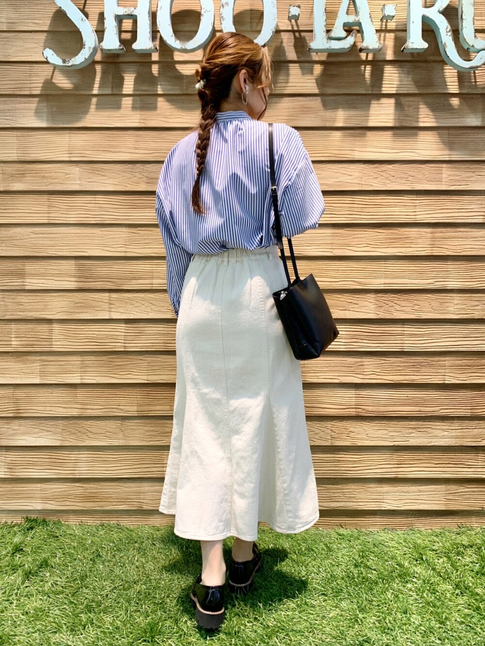 ブルー系のワンピース、ホワイト系のデニムスカート、ブラック系のショルダーバッグを着用したレディースの春コーディネートの5枚目の写真