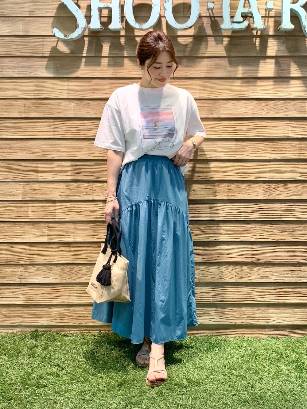 ホワイト系のTシャツ/カットソー、ブルー系のスカート、ブラック系のトートバッグを着用したレディースの秋コーディネートの3枚目の写真