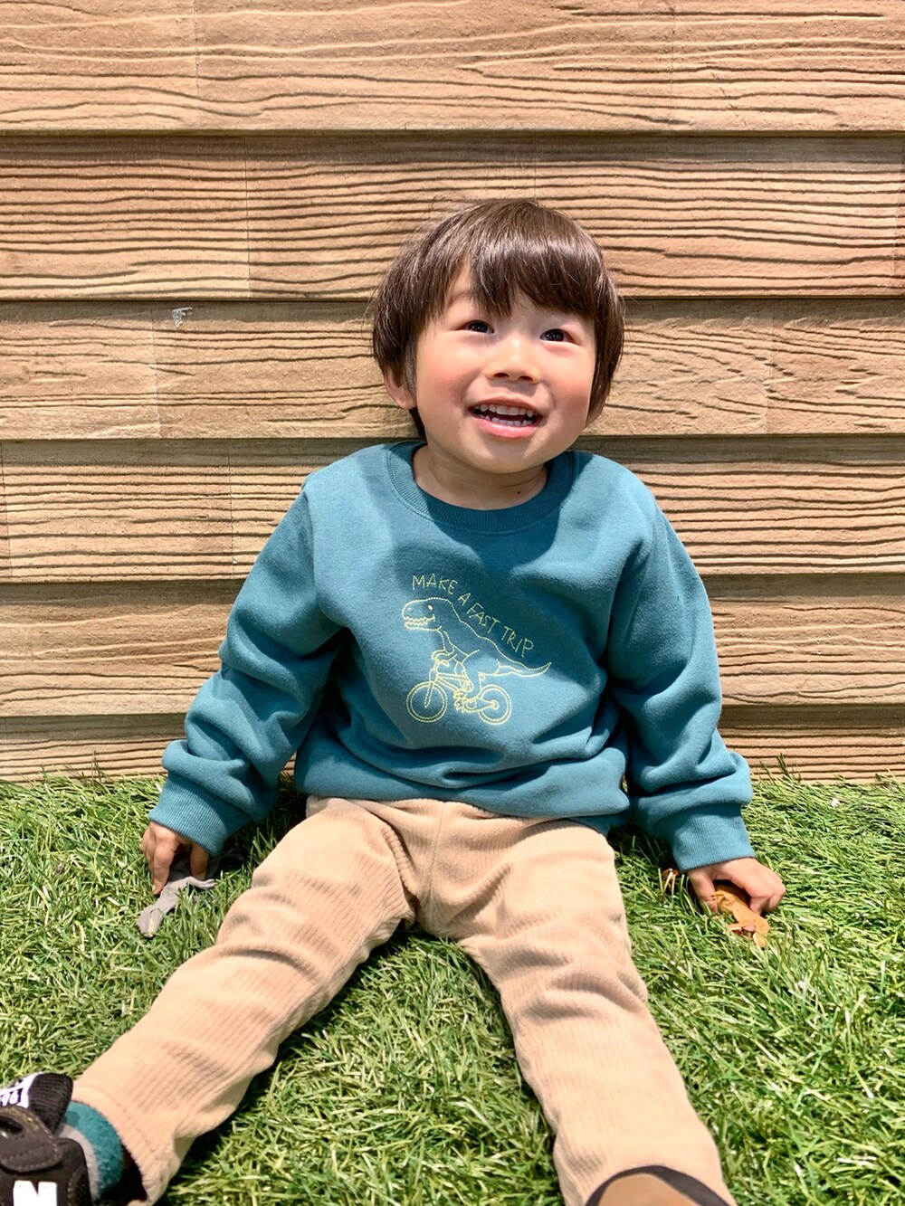グリーン系のスウェット、ベージュ系のパンツ、ホワイト系のその他を着用したキッズの冬コーディネートの4枚目の写真