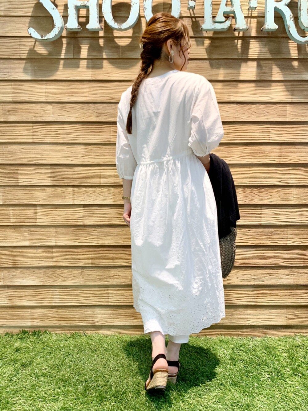 ホワイト系のワンピース、ブラック系のカーディガン/ボレロ、ホワイト系のその他パンツを着用したレディースの春コーディネートの5枚目の写真