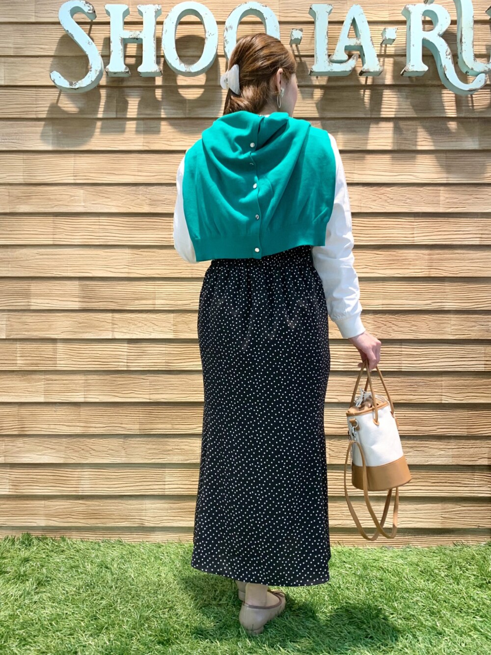 ホワイト系のTシャツ/カットソー、グリーン系のカーディガン/ボレロ、ブラック系のスカートを着用したレディースの春コーディネートの5枚目の写真