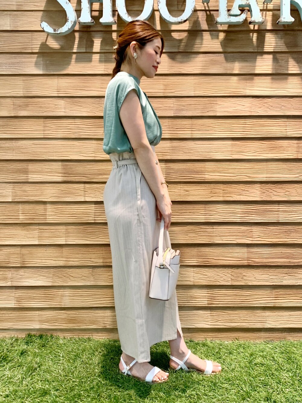 グリーン系のシャツ/ブラウス、ベージュ系のスカート、ホワイト系のショルダーバッグを着用したレディースの夏コーディネートの4枚目の写真