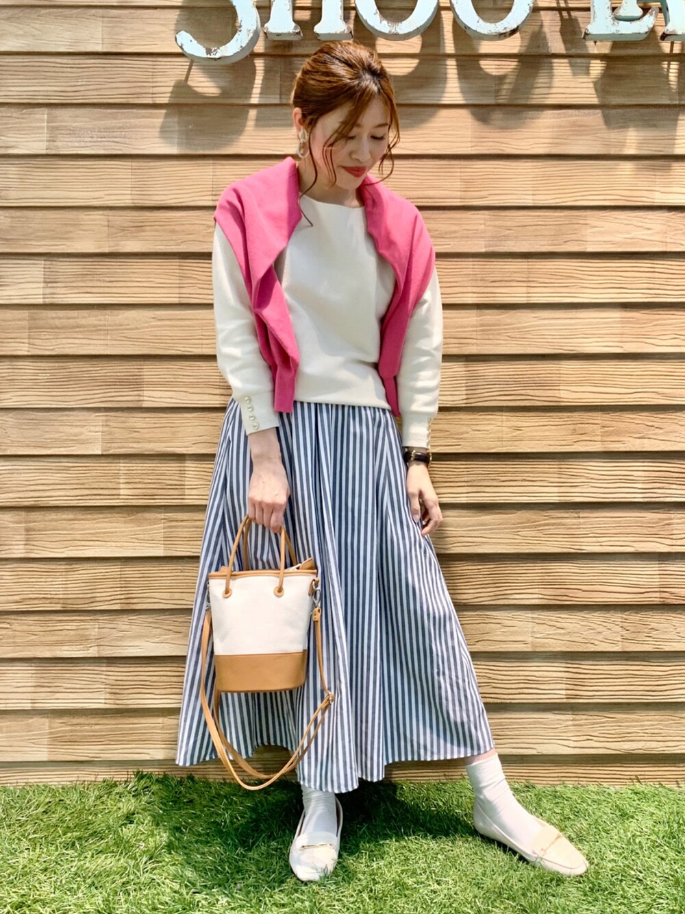 ピンク系のニット/セーター、ホワイト系のニット/セーター、ブルー系のスカートを着用したレディースの春コーディネートの3枚目の写真