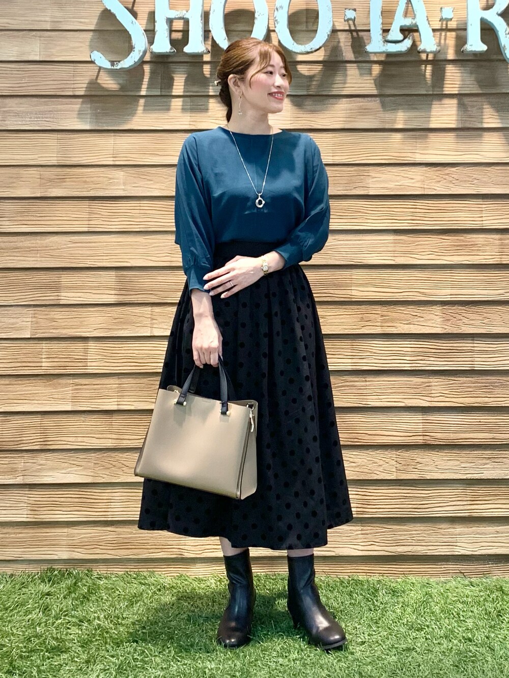 ブルー系のシャツ/ブラウス、グレー系のスカート、ベージュ系のトートバッグを着用したレディースの冬コーディネートの2枚目の写真