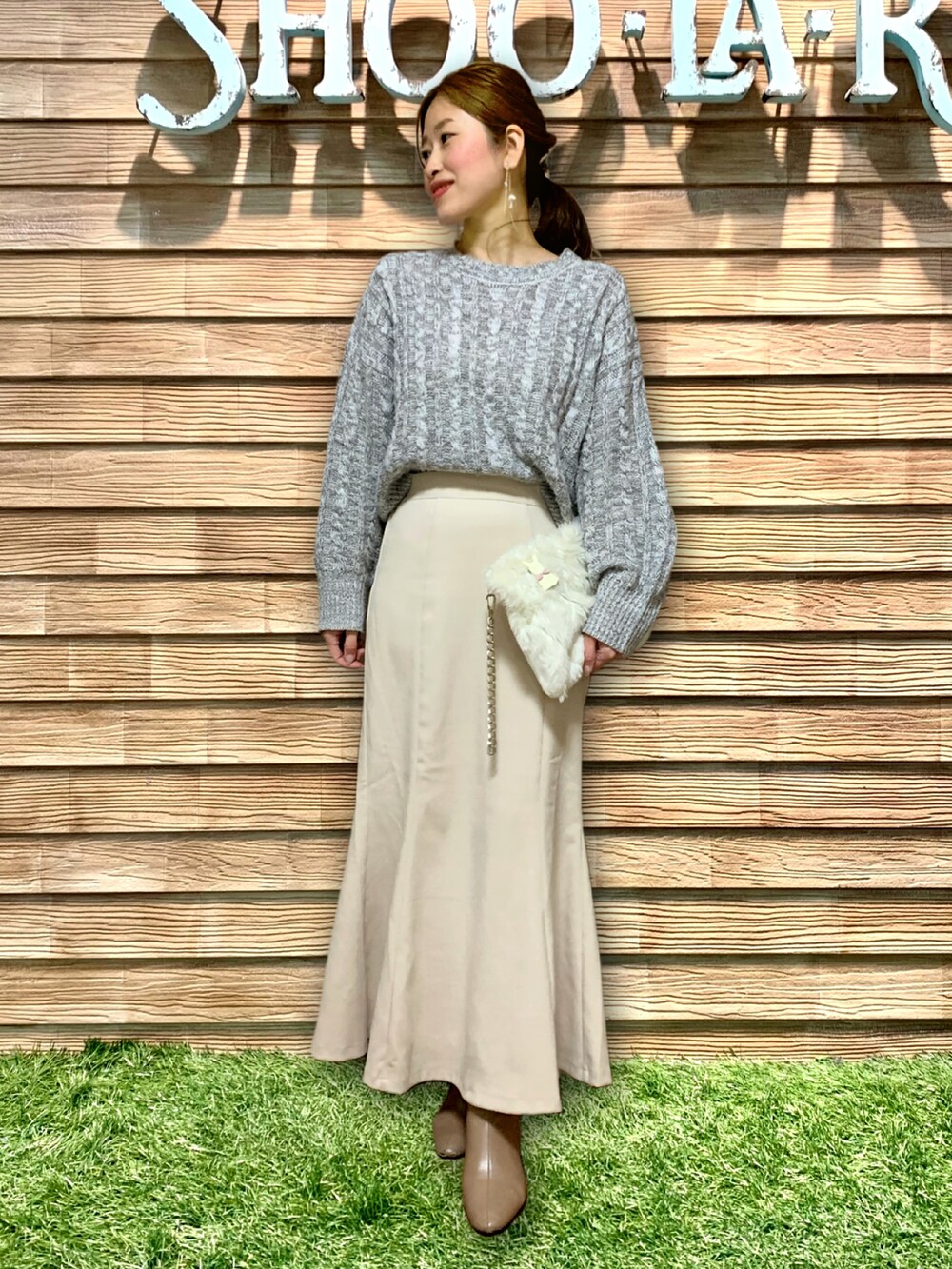 グレー系のニット/セーター、ホワイト系のスカート、ベージュ系のブーツを着用したレディースの冬コーディネートの2枚目の写真