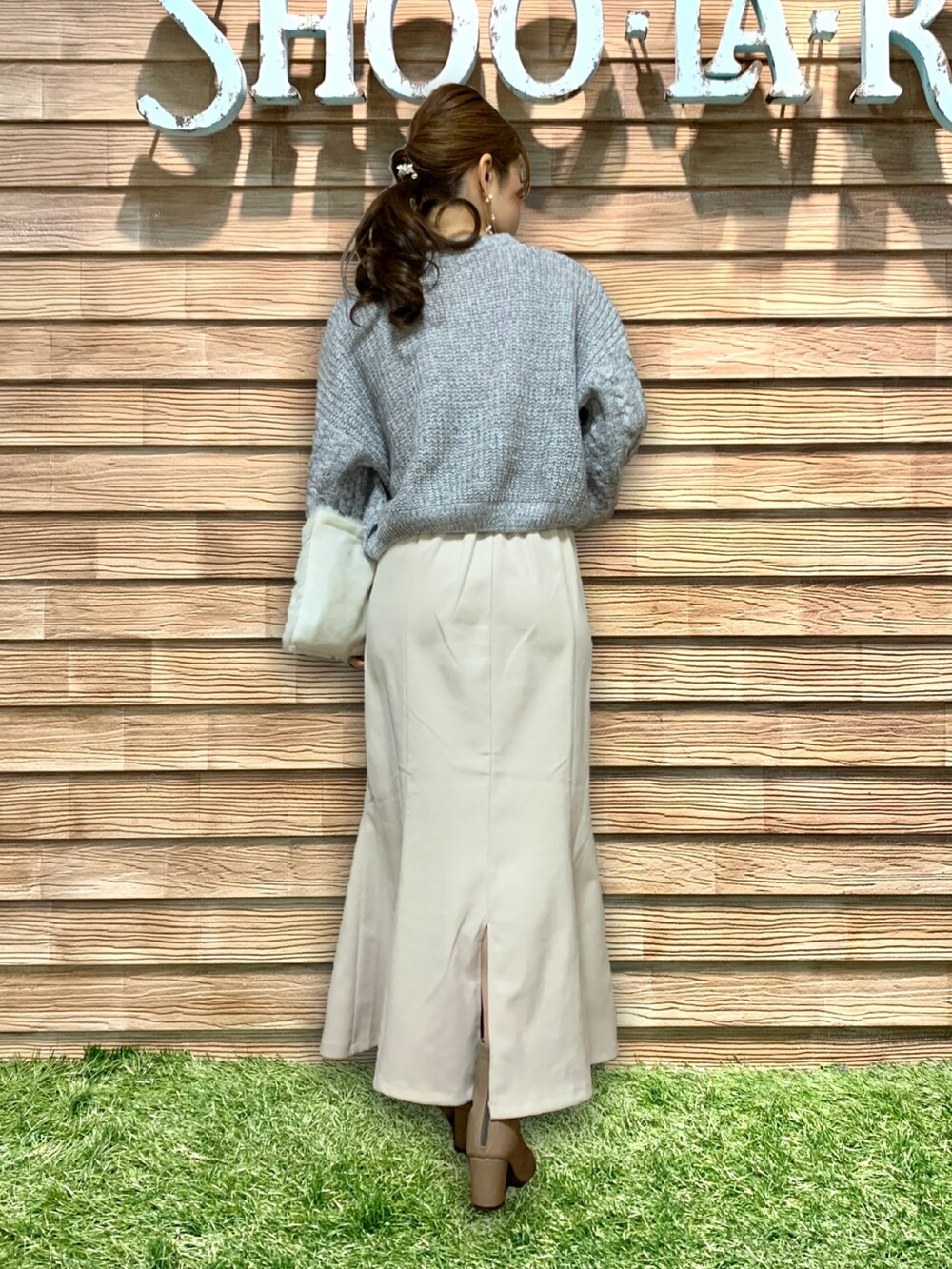 グレー系のニット/セーター、ホワイト系のスカート、ベージュ系のブーツを着用したレディースの冬コーディネートの5枚目の写真