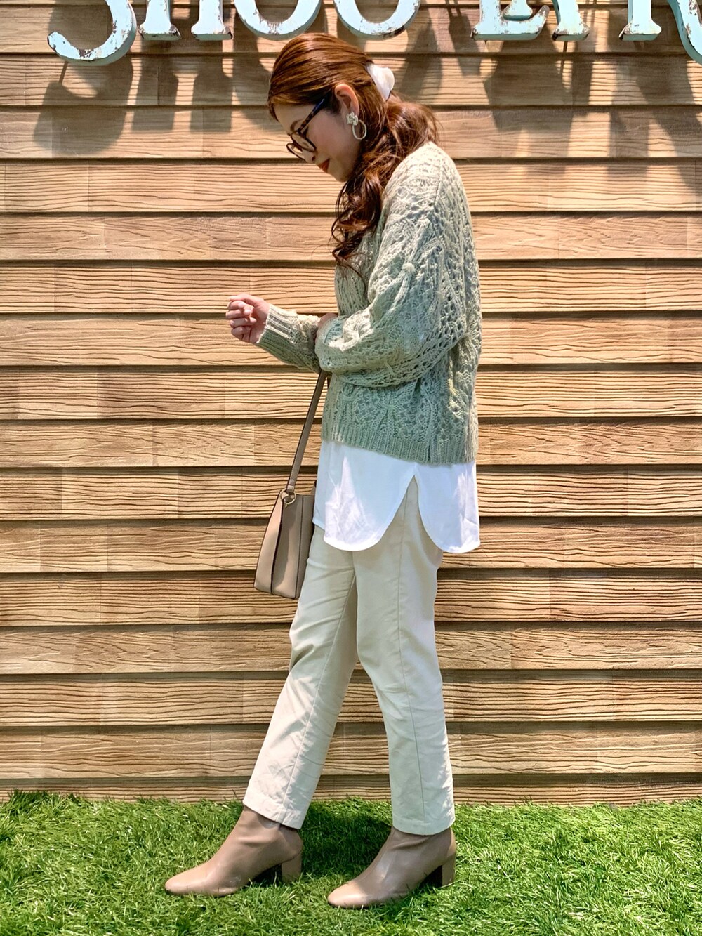 ベージュ系のダウンジャケット/コート、グリーン系のニット/セーター、ホワイト系のその他パンツを着用したレディースの冬コーディネートの5枚目の写真