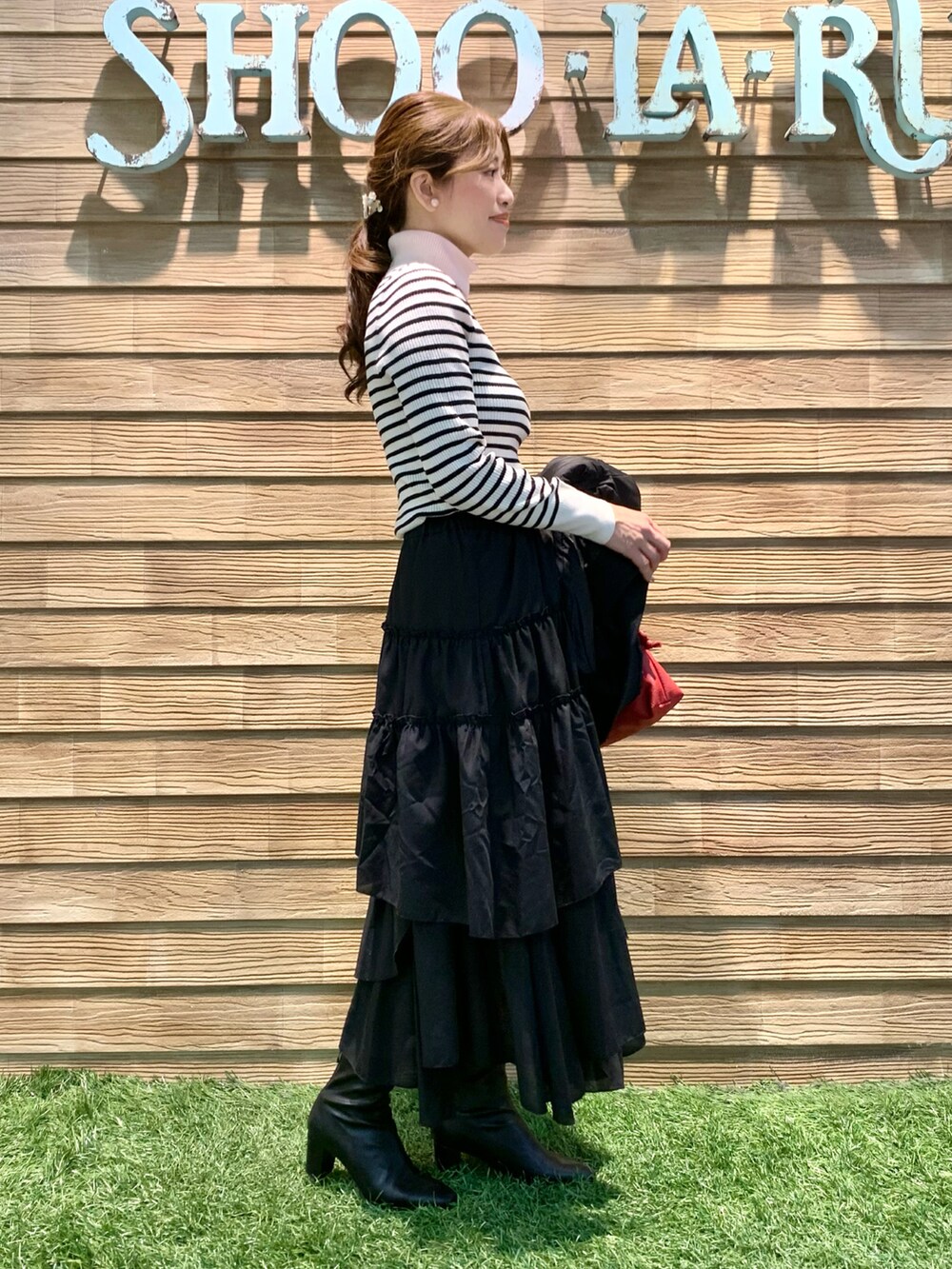 ブラック系のブルゾン、ホワイト系のニット/セーター、ブラック系のスカートを着用したレディースの秋コーディネートの4枚目の写真