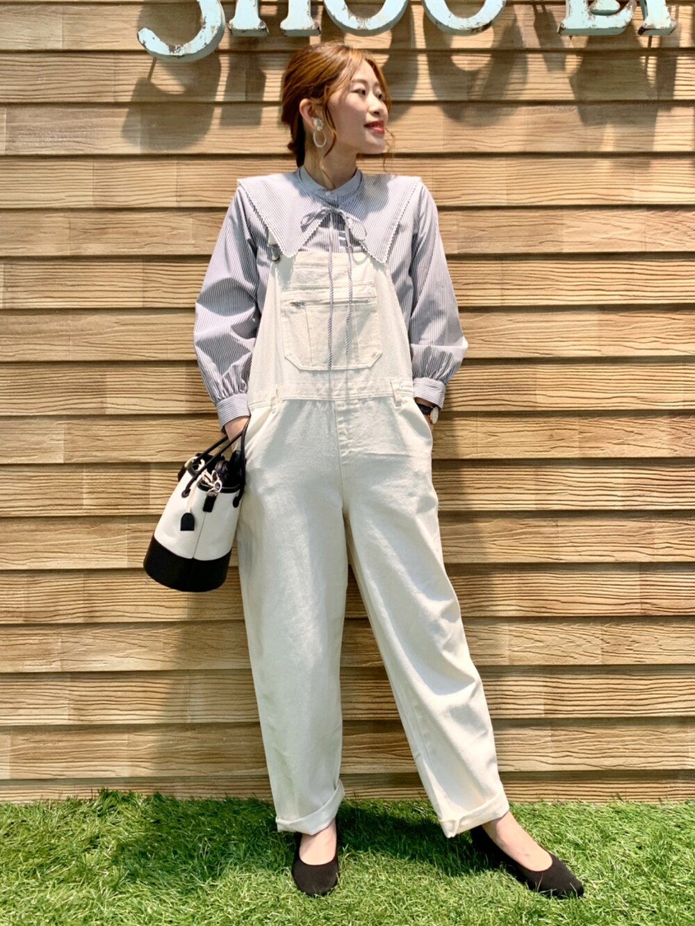 グレー系のシャツ/ブラウス、ホワイト系のサロペット/オーバーオール、ブラック系のハンドバッグを着用したレディースの冬コーディネートの2枚目の写真
