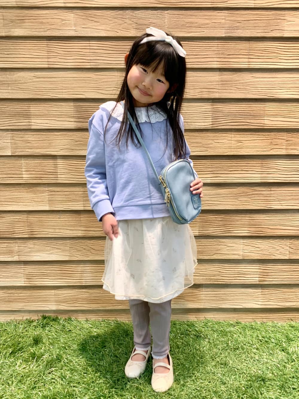 ブルー系のスウェット、ホワイト系のスカート、ブラウン系のその他パンツを着用したキッズの春コーディネートの3枚目の写真