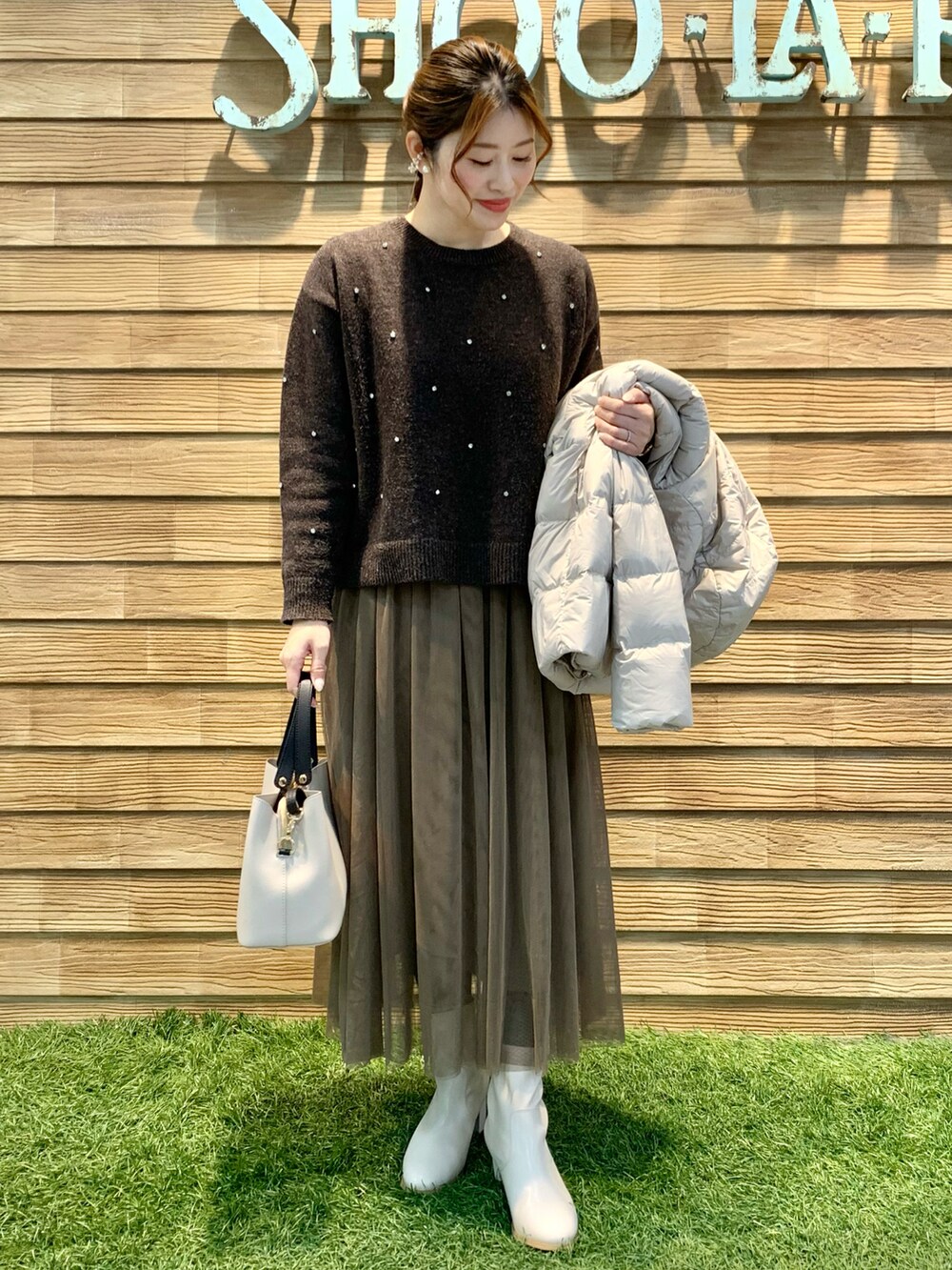 ブラウン系のニット/セーター、ブラウン系のスカート、ベージュ系のトートバッグを着用したレディースの冬コーディネートの3枚目の写真