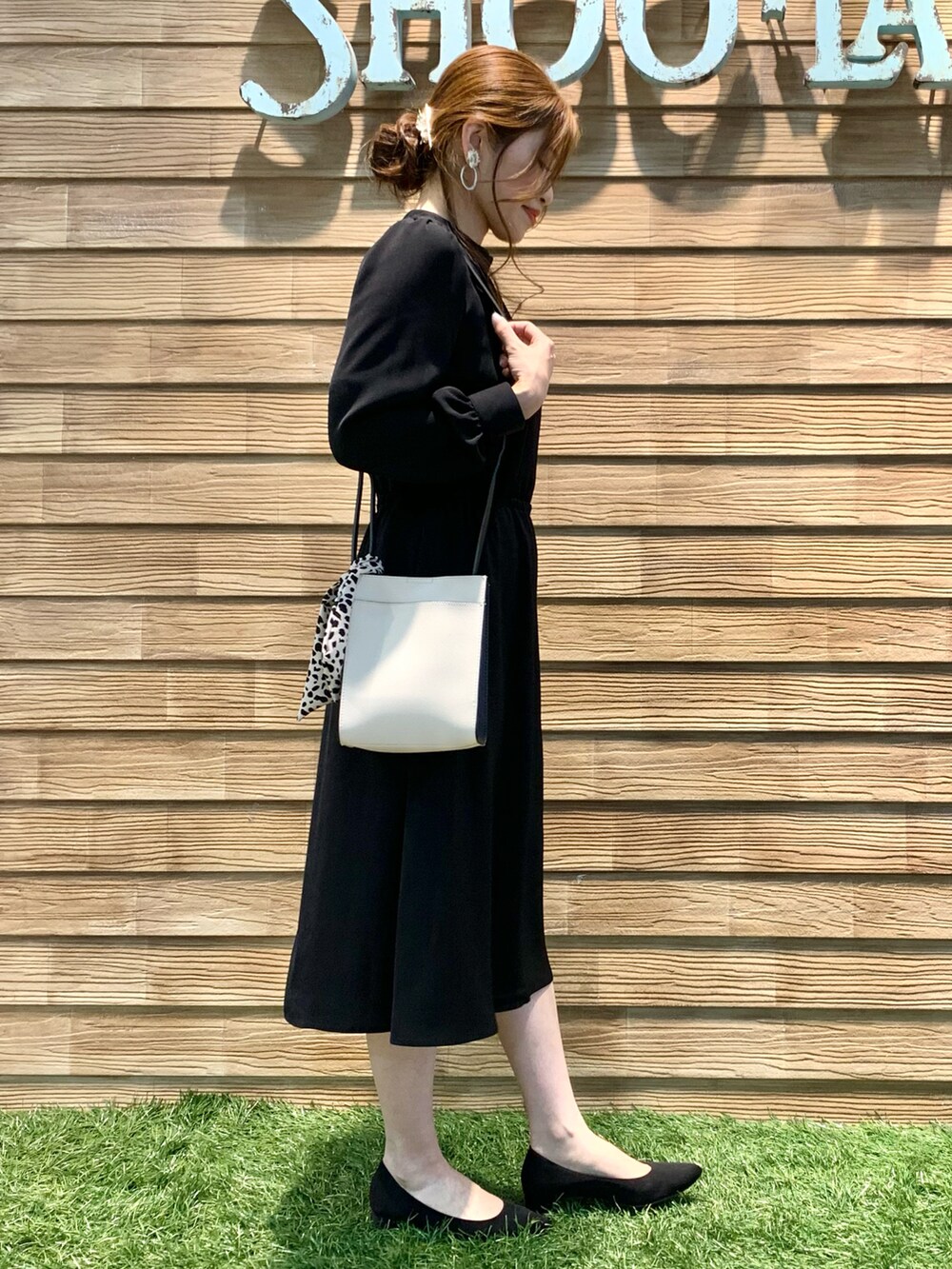 ブラック系のワンピース、ブラック系のショルダーバッグ、ブラック系のパンプスを着用したレディースの冬コーディネートの3枚目の写真