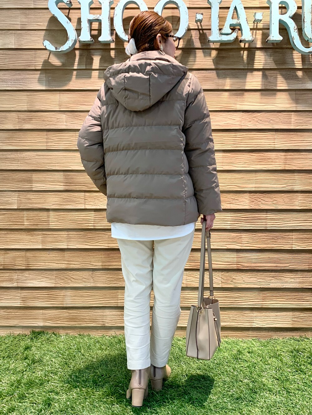 ベージュ系のダウンジャケット/コート、グリーン系のニット/セーター、ホワイト系のその他パンツを着用したレディースの冬コーディネートの3枚目の写真