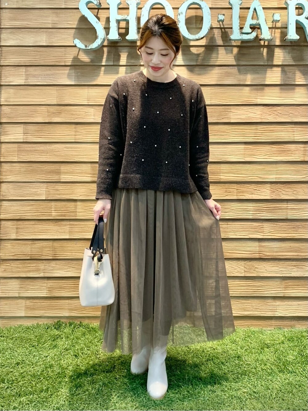 ブラウン系のスカート、ベージュ系のトートバッグを着用したレディースの冬コーディネートの4枚目の写真