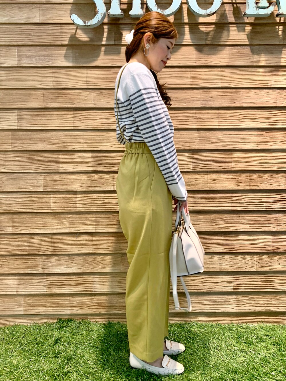 グレー系のニット/セーター、イエロー系のその他パンツ、ホワイト系のトートバッグを着用したレディースの冬コーディネートの4枚目の写真
