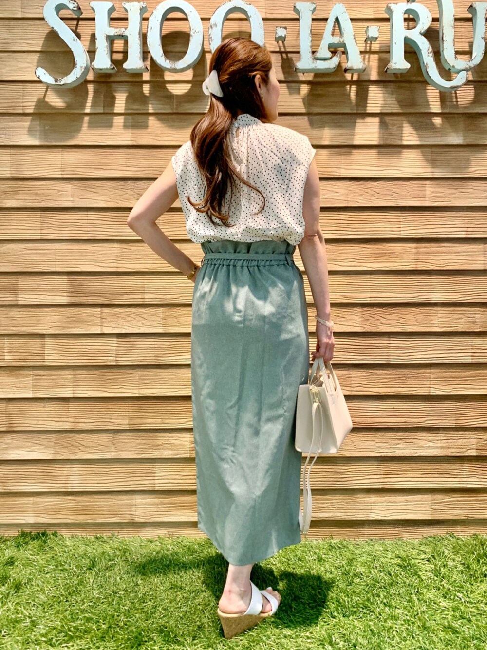 ベージュ系のシャツ/ブラウス、グリーン系のスカート、ホワイト系のショルダーバッグを着用したレディースの夏コーディネートの5枚目の写真