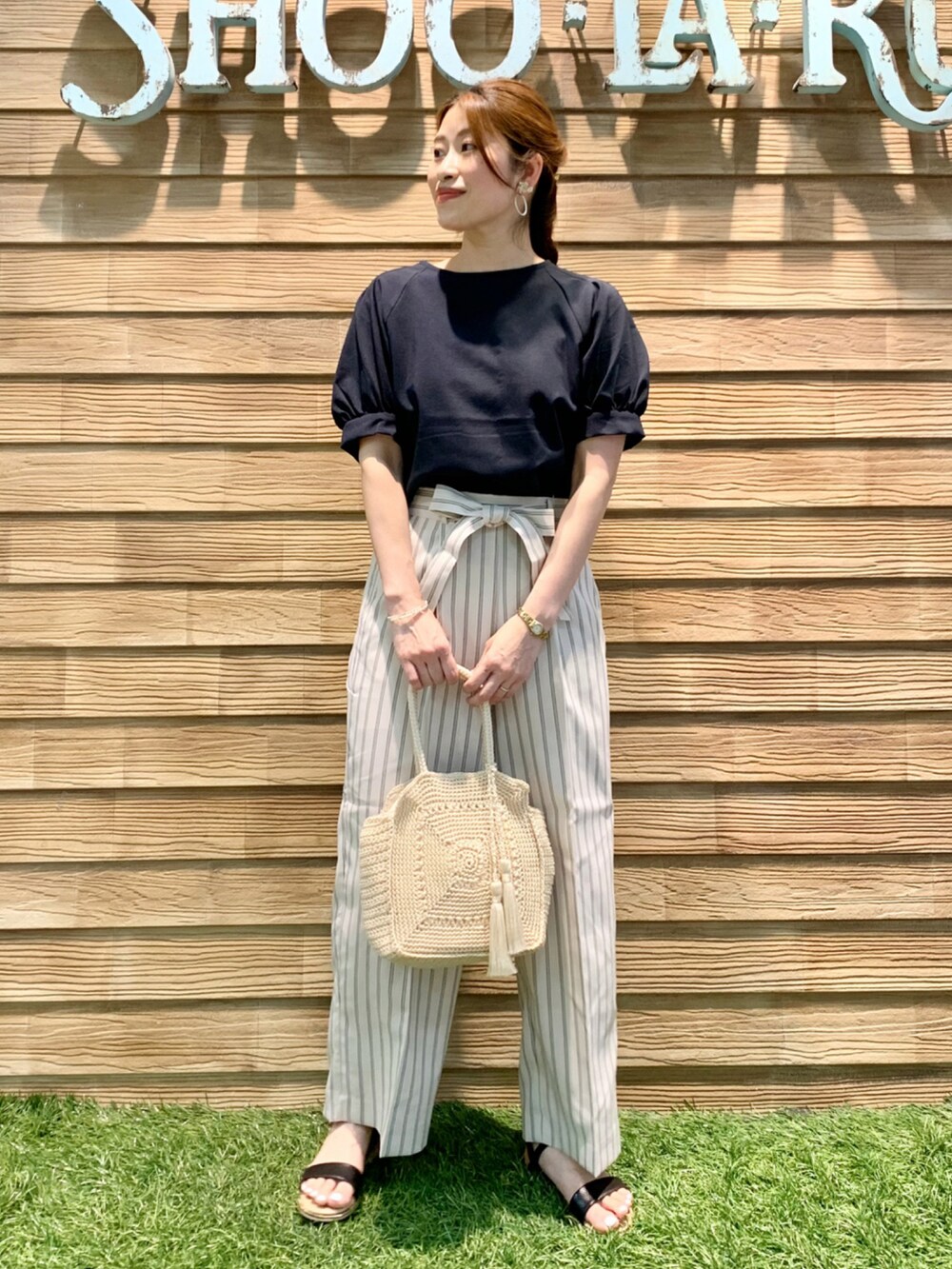 ブルー系のシャツ/ブラウス、ベージュ系のその他パンツ、ベージュ系のハンドバッグを着用したレディースの夏コーディネートの2枚目の写真