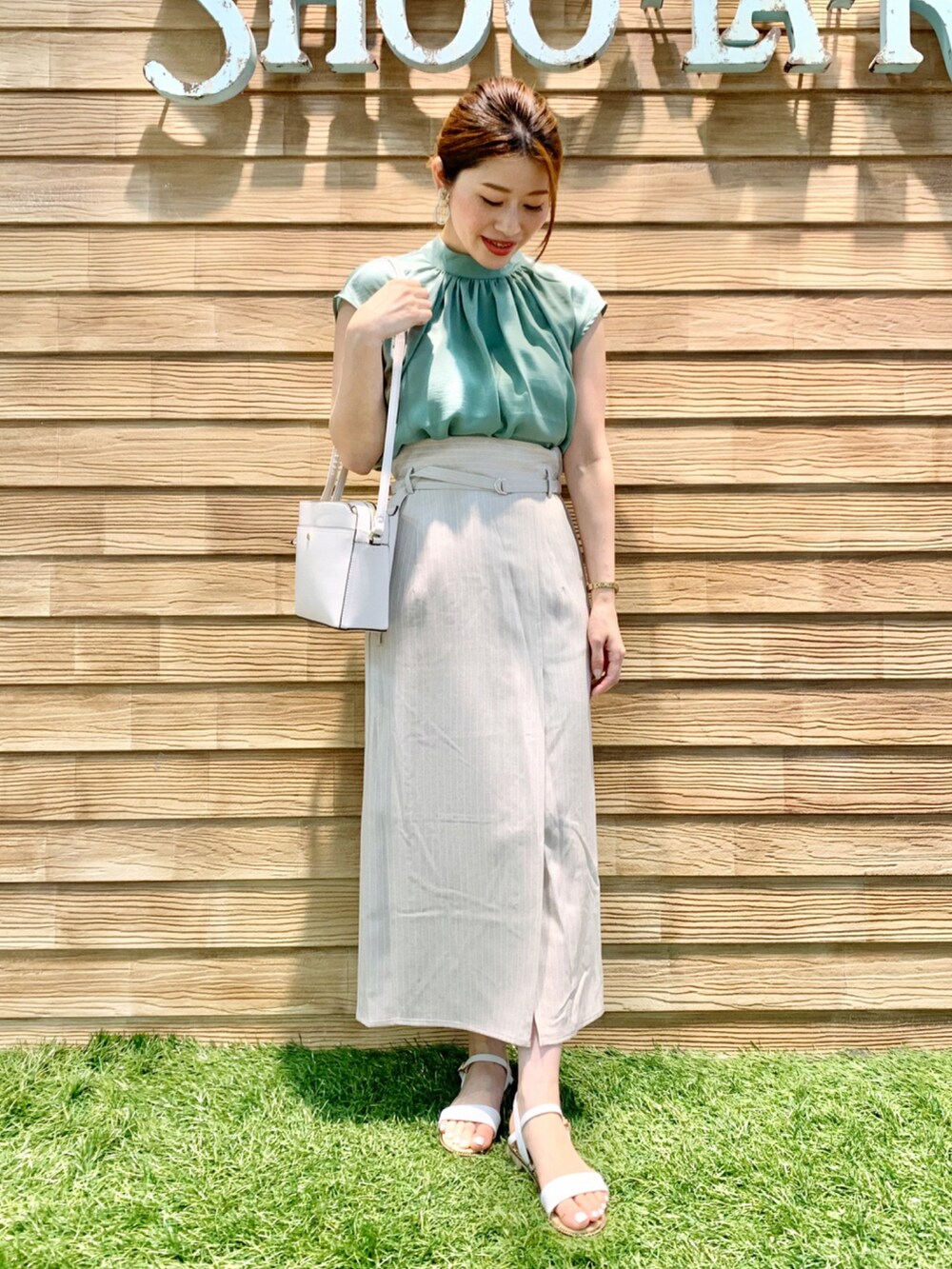 グリーン系のシャツ/ブラウス、ベージュ系のスカート、ホワイト系のショルダーバッグを着用したレディースの夏コーディネートの3枚目の写真