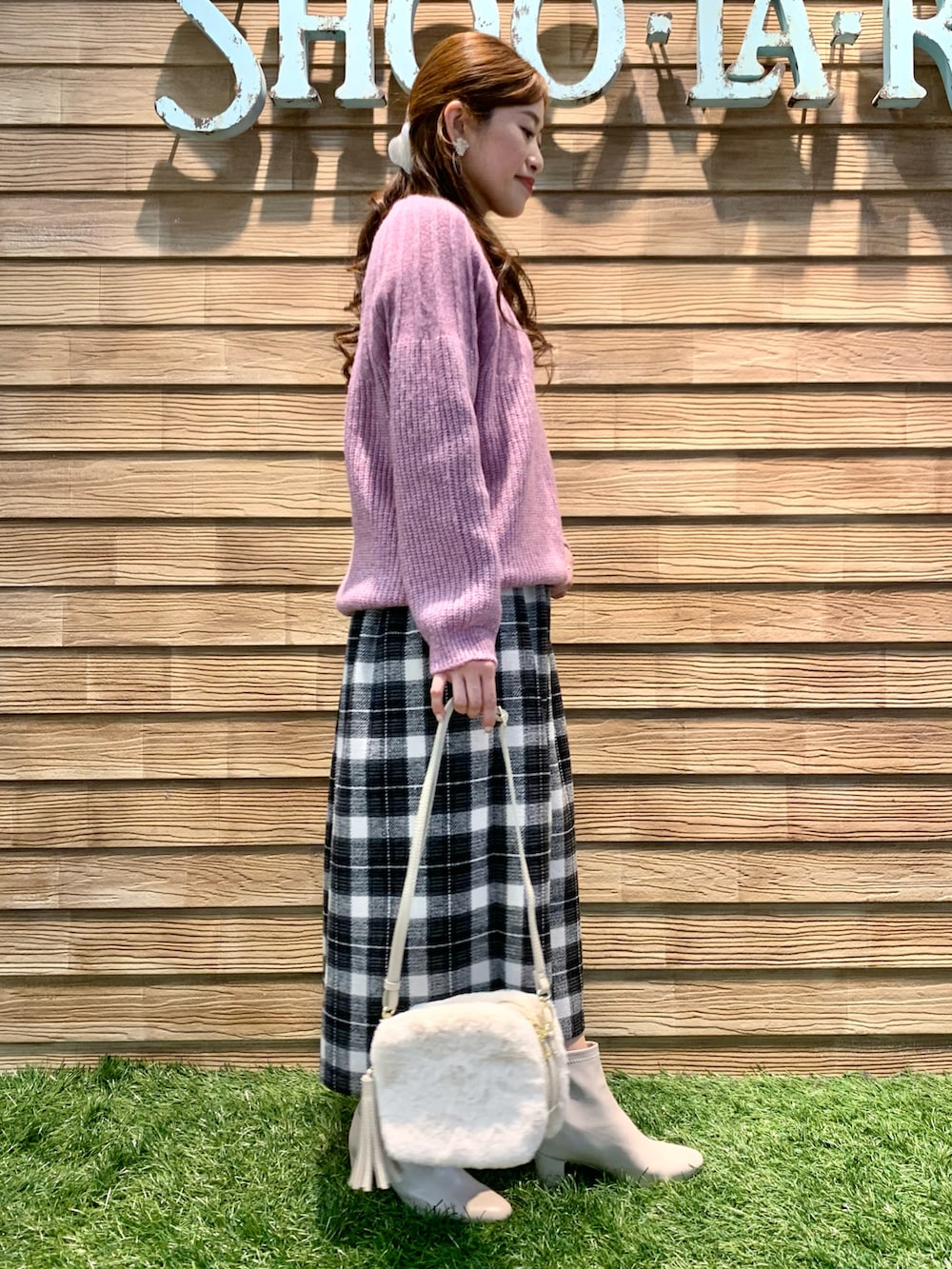 ピンク系のニット/セーター、グレー系のスカート、ホワイト系のショルダーバッグを着用したレディースの冬コーディネートの5枚目の写真