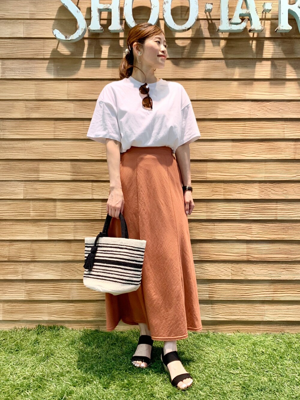 ホワイト系のTシャツ/カットソー、オレンジ系のスカート、ブラック系のトートバッグを着用したレディースの夏コーディネートの3枚目の写真