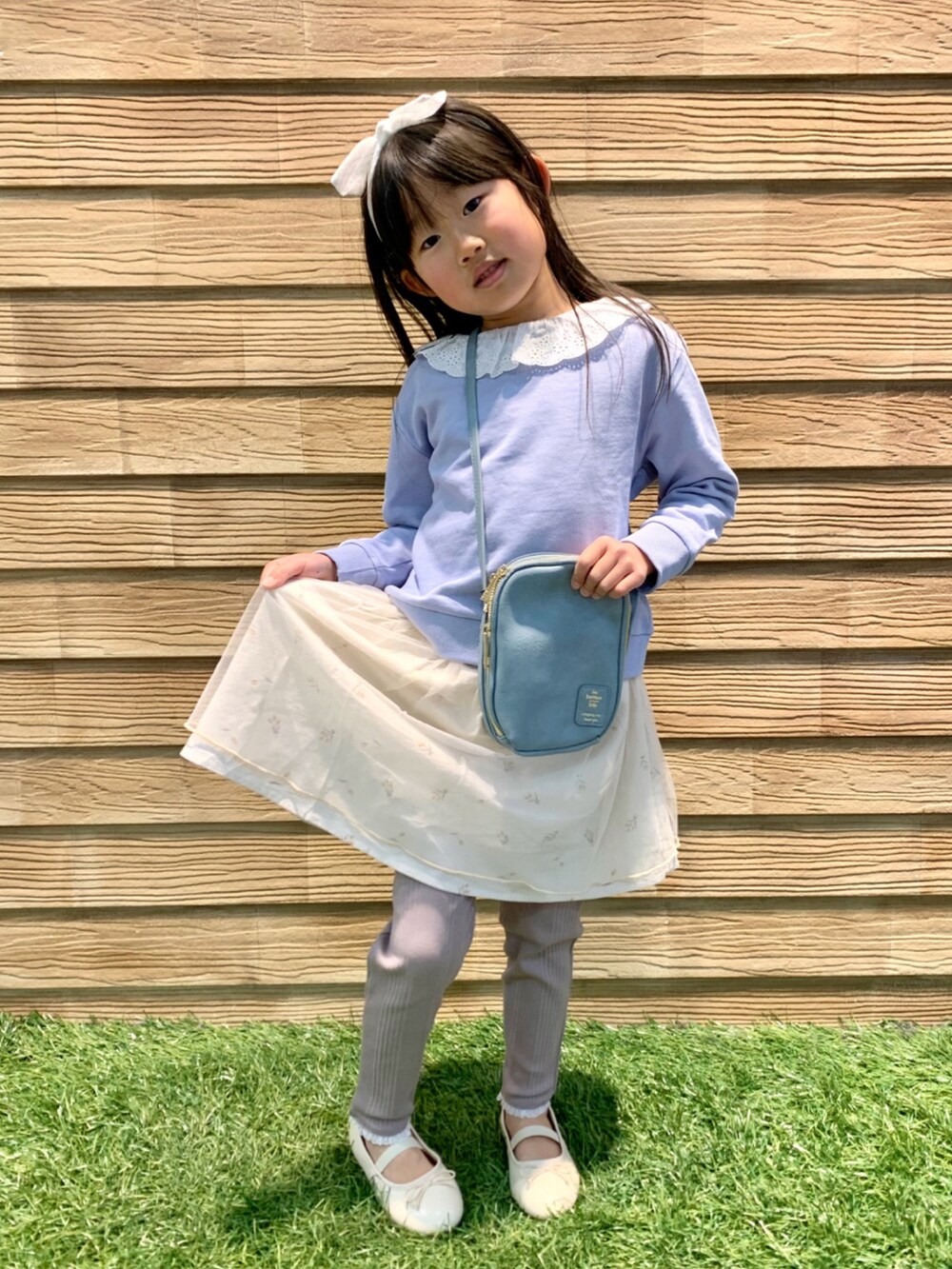 ブルー系のスウェット、ホワイト系のスカート、ブラウン系のその他パンツを着用したキッズの春コーディネートの4枚目の写真