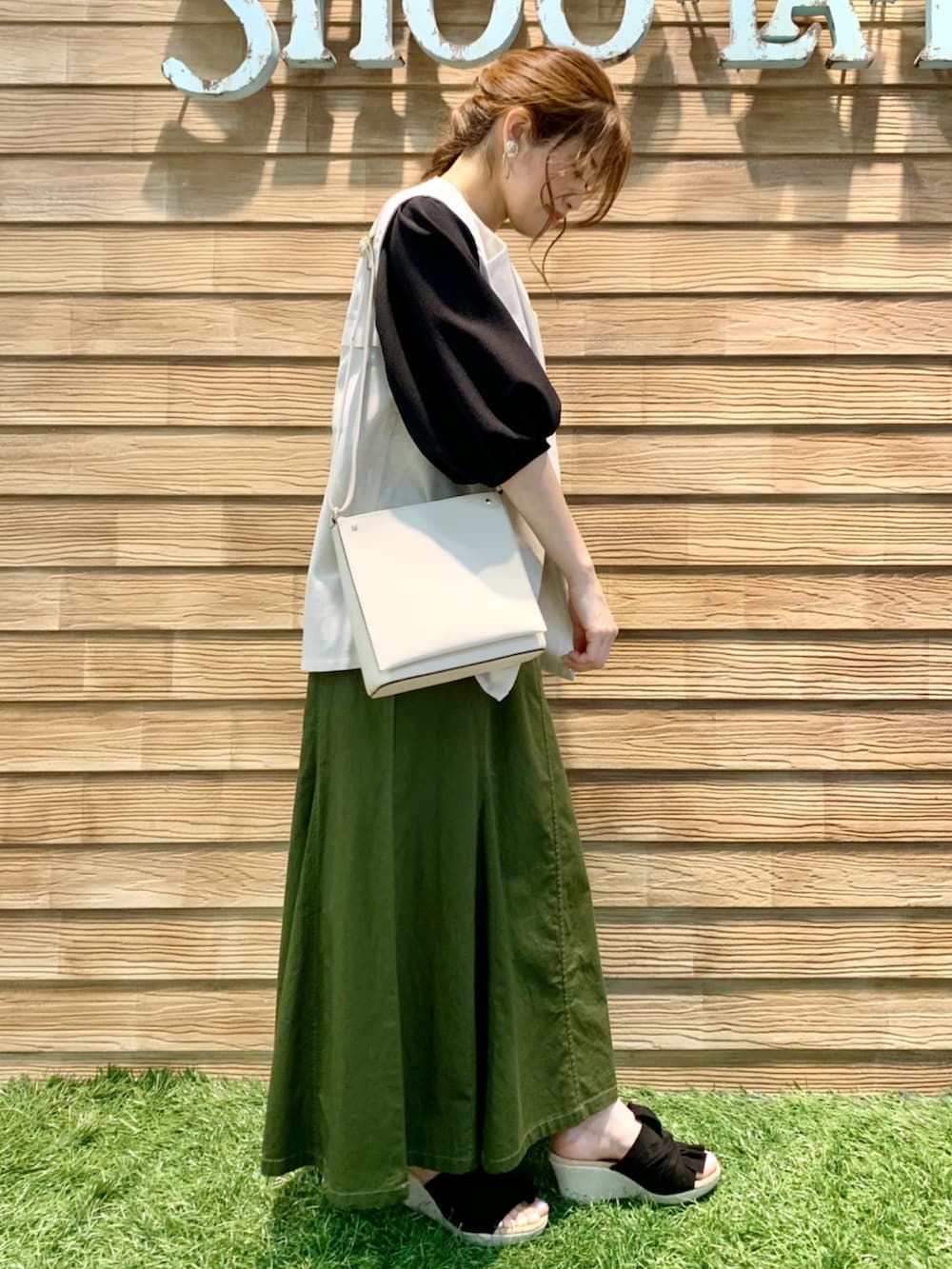 ベージュ系のベスト、ブラック系のTシャツ/カットソー、グリーン系のスカートを着用したレディースの夏コーディネートの4枚目の写真