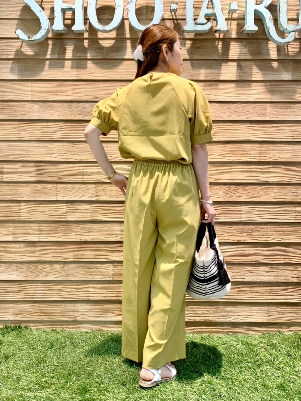 イエロー系のシャツ/ブラウス、イエロー系のその他パンツ、ブラック系のトートバッグを着用したレディースの夏コーディネートの5枚目の写真