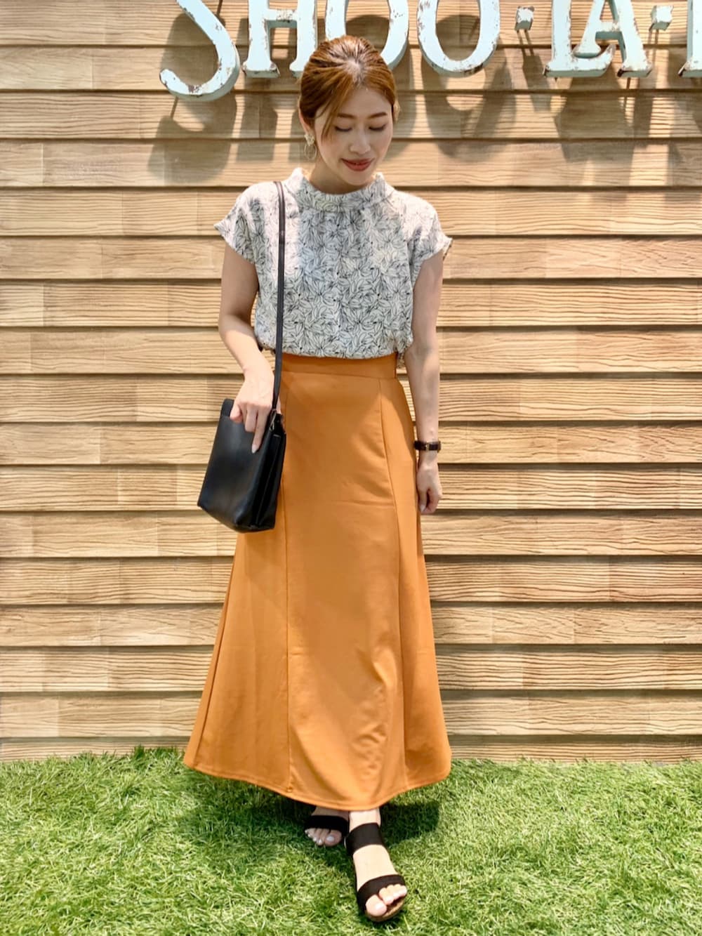 ホワイト系のシャツ/ブラウス、オレンジ系のスカート、ブラック系のショルダーバッグを着用したレディースの秋コーディネートの3枚目の写真