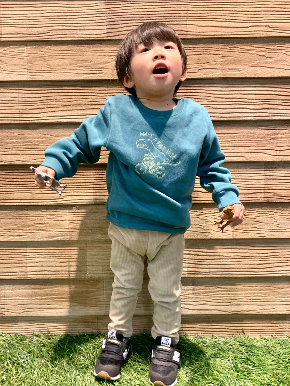 グリーン系のスウェット、ベージュ系のパンツ、ホワイト系のその他を着用したキッズの冬コーディネートの2枚目の写真
