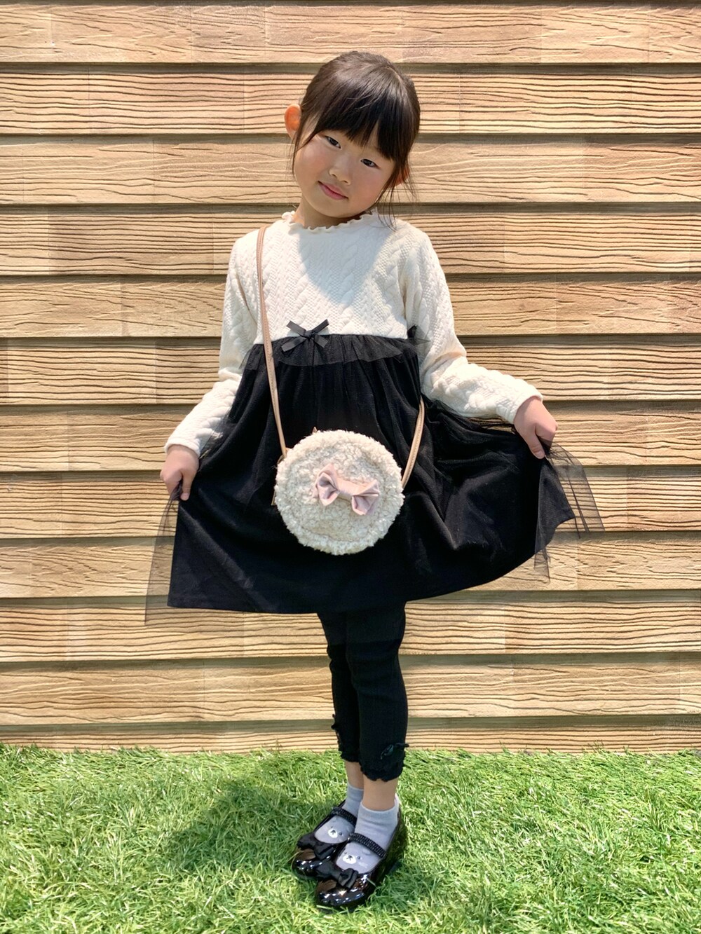 ピンク系のダウンジャケット/コート、ベージュ系のワンピース、ブラック系のその他パンツを着用したキッズの冬コーディネートの4枚目の写真