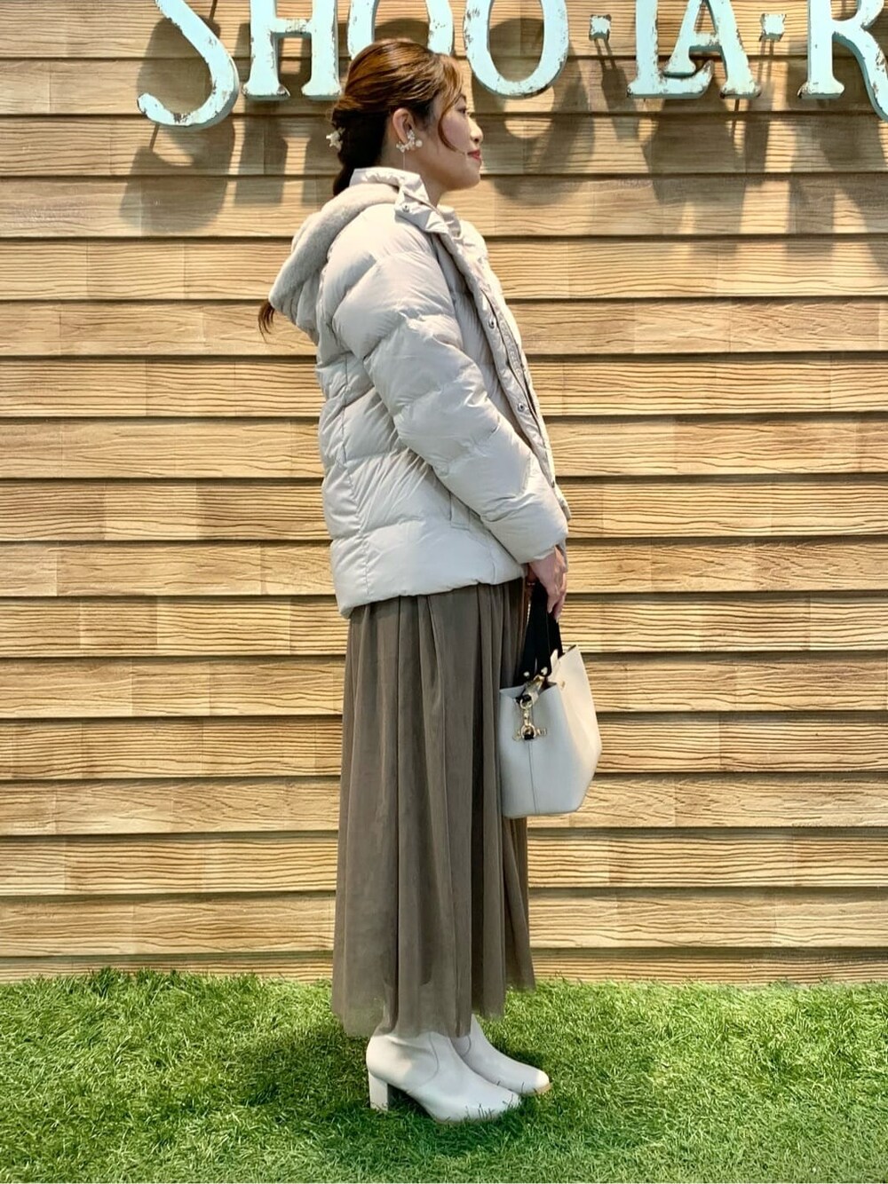 ブラウン系のスカート、ベージュ系のトートバッグを着用したレディースの冬コーディネートの2枚目の写真