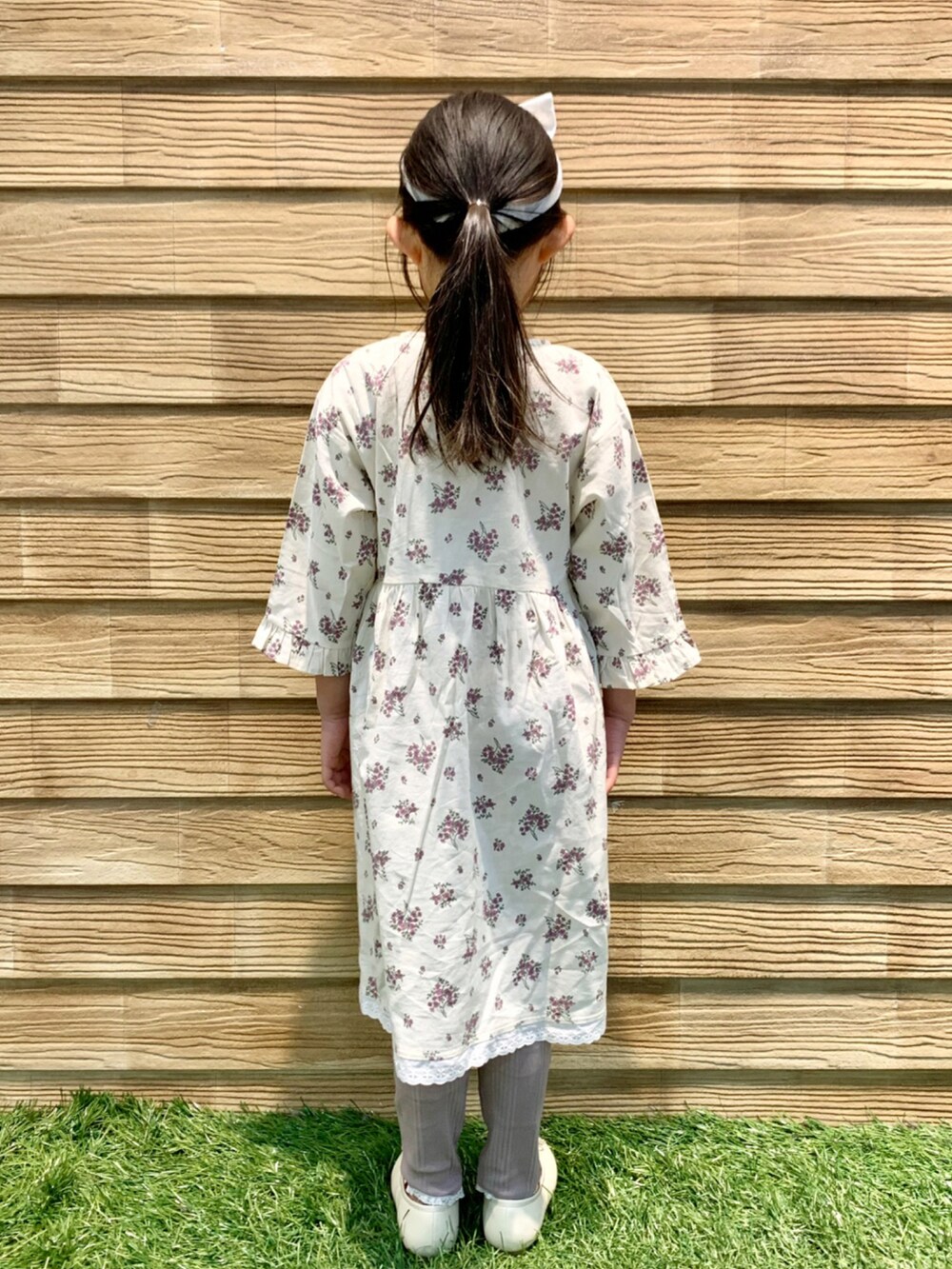 ベージュ系のワンピース、ブラウン系のその他パンツ、グリーン系のラッピングキットを着用したキッズの春コーディネートの4枚目の写真