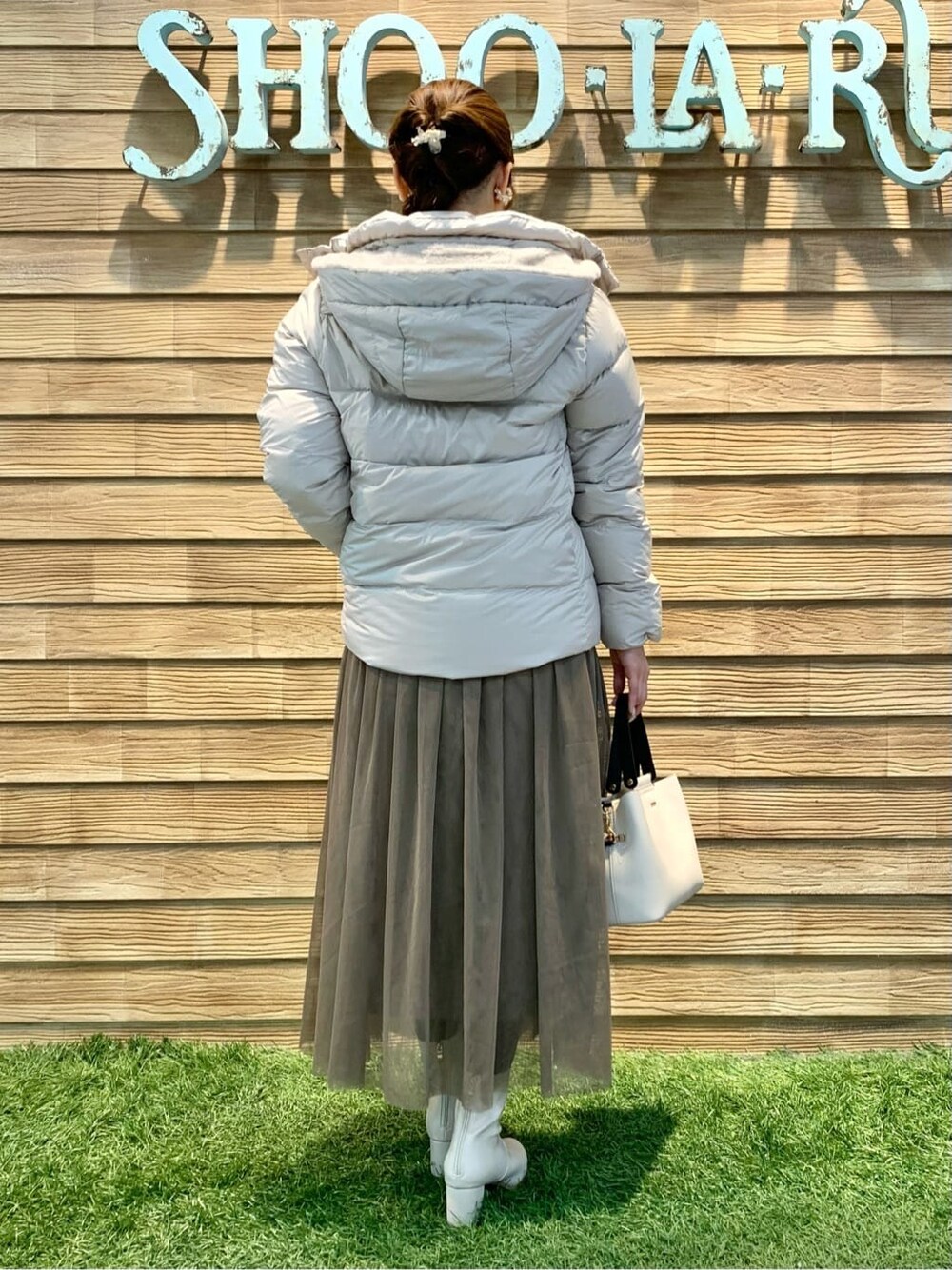 ブラウン系のスカート、ベージュ系のトートバッグを着用したレディースの冬コーディネートの3枚目の写真