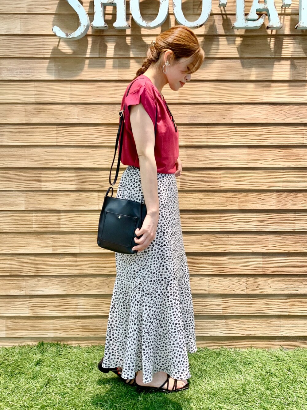 ピンク系のTシャツ/カットソー、ホワイト系のスカート、ブラック系のショルダーバッグを着用したレディースの秋コーディネートの4枚目の写真